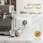 مقبس كهربائي أبيض موصل بقابس ماكينة قهوة على سطح مطبخ، بجانب فنجان
